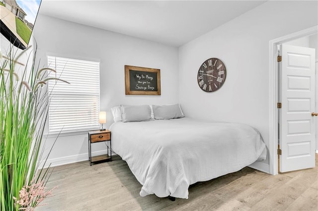 bedroom with baseboards and wood finished floors
