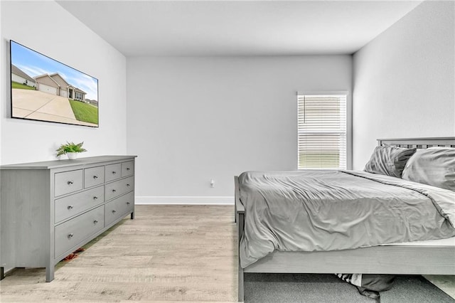 bedroom featuring light wood-style flooring and baseboards