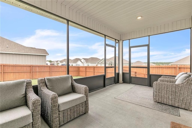 sunroom / solarium featuring plenty of natural light and a residential view
