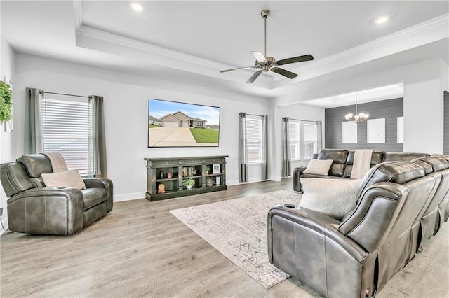 living area featuring a raised ceiling, a chandelier, wood finished floors, a ceiling fan, and recessed lighting