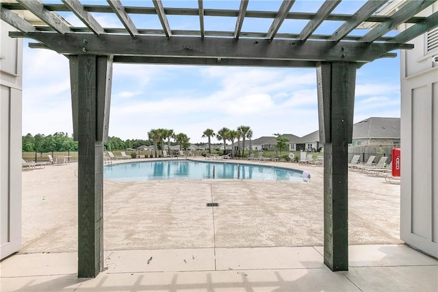 community pool with a pergola and a patio area