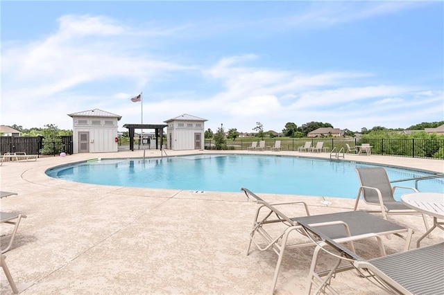 community pool featuring fence and a patio