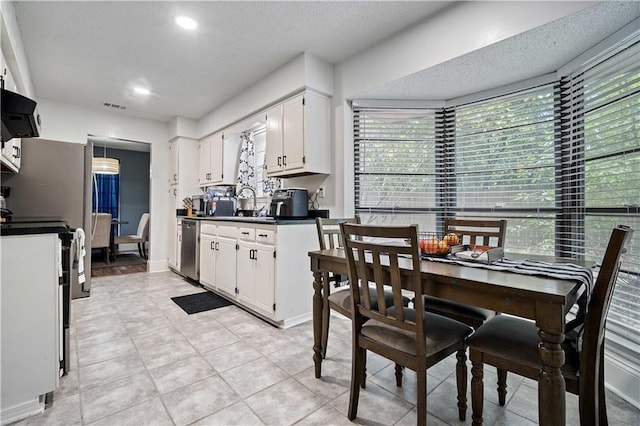 2017 Knollwood Dr, Mobile, AL 36609 - kitchen with appliances with stainless steel finishes, white cabinetry, dark countertops, recessed lighting, and light tile patterned floors