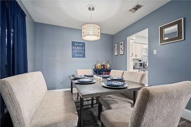 2017 Knollwood Dr, Mobile, AL 36609 - dining room featuring a textured ceiling, baseboards, and wood finished floors