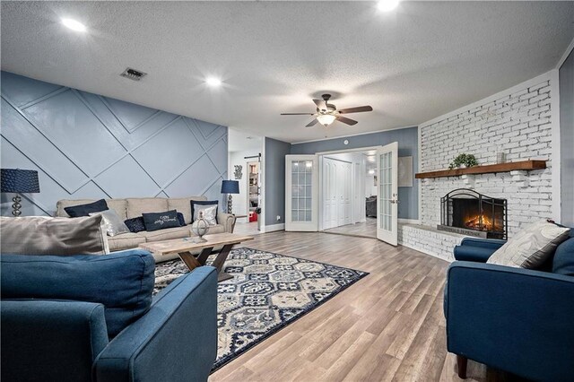 2017 Knollwood Dr, Mobile, AL 36609 - living area featuring a ceiling fan, wood finished floors, a textured ceiling, a brick fireplace, and baseboards