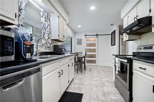 2017 Knollwood Dr, Mobile, AL 36609 - kitchen with stainless steel appliances, under cabinet range hood, a barn door, white cabinetry, and a sink