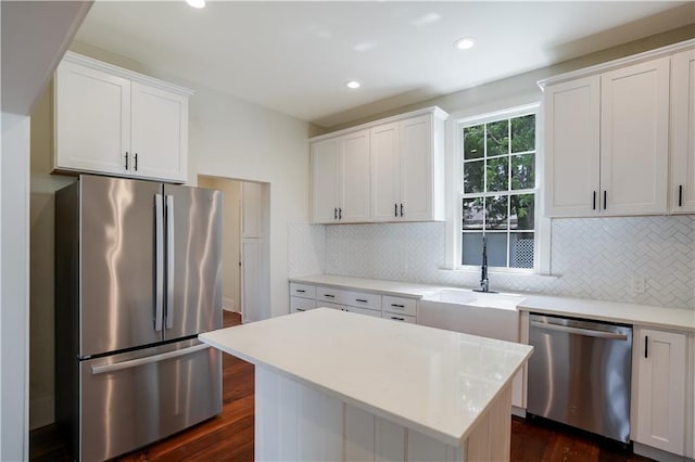 kitchen with sink, dark wood-type flooring, white cabinetry, stainless steel appliances, and tasteful backsplash