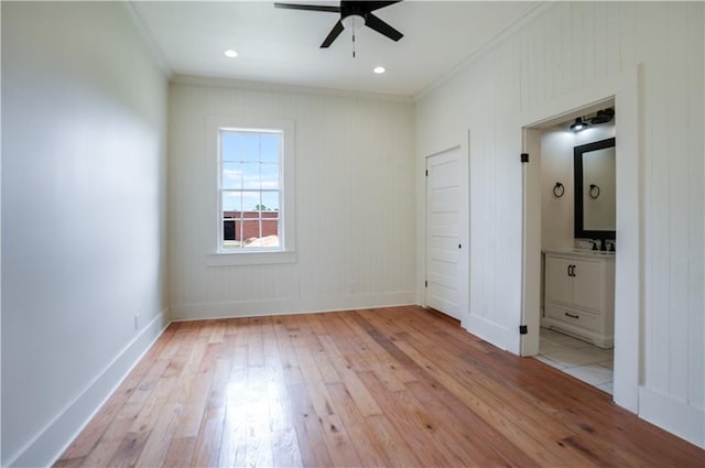 unfurnished bedroom with crown molding, sink, connected bathroom, and light hardwood / wood-style floors