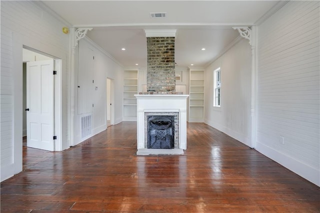 unfurnished living room with ornamental molding, dark hardwood / wood-style floors, decorative columns, and built in features