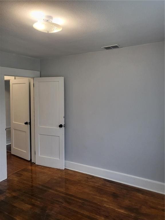 spare room with dark hardwood / wood-style floors