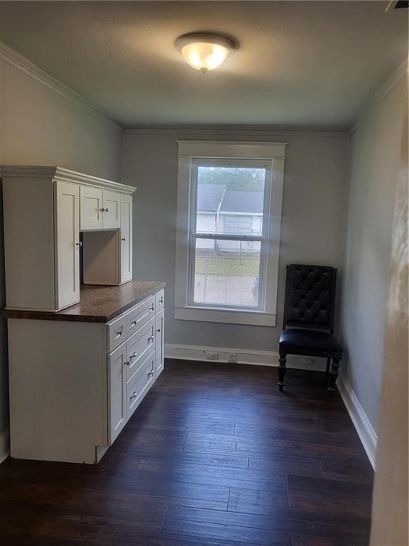 kitchen with ornamental molding, white cabinets, and dark hardwood / wood-style flooring