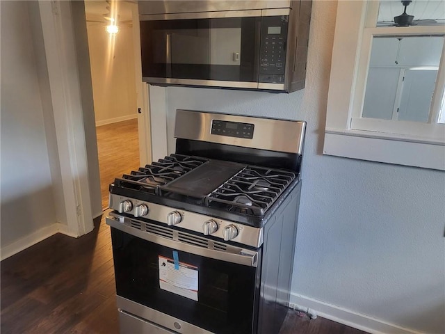 kitchen featuring ceiling fan, dark wood-type flooring, and stainless steel appliances