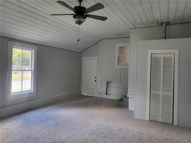 interior space with ceiling fan, lofted ceiling, carpet flooring, and wood ceiling