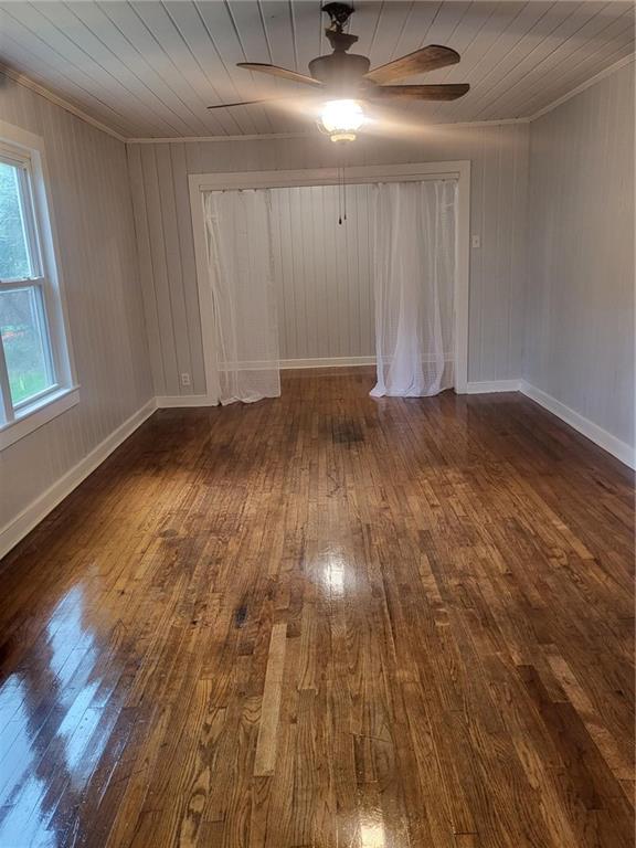 empty room featuring wood ceiling, ceiling fan, dark hardwood / wood-style floors, and crown molding