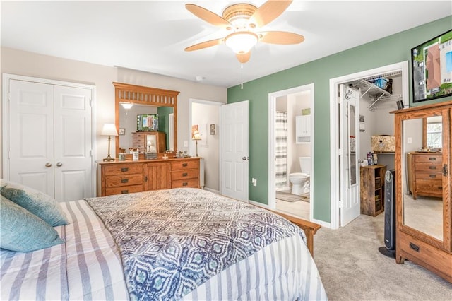 bedroom with light carpet, a closet, connected bathroom, and ceiling fan