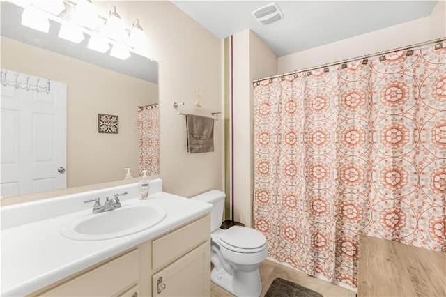 bathroom with a shower with shower curtain, tile patterned flooring, vanity, and toilet