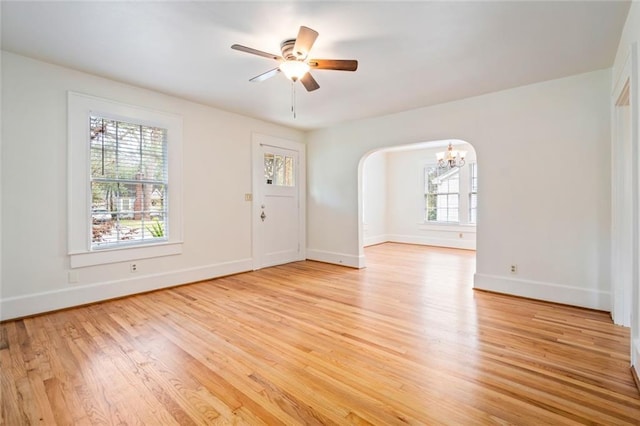 interior space with ceiling fan with notable chandelier and light hardwood / wood-style flooring