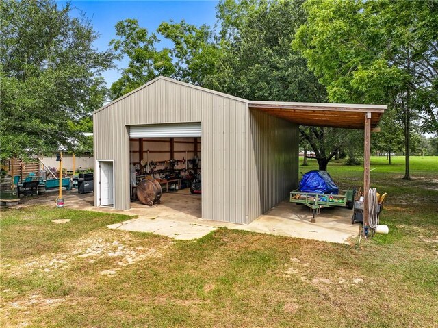 view of outdoor structure with a lawn, a garage, and a carport