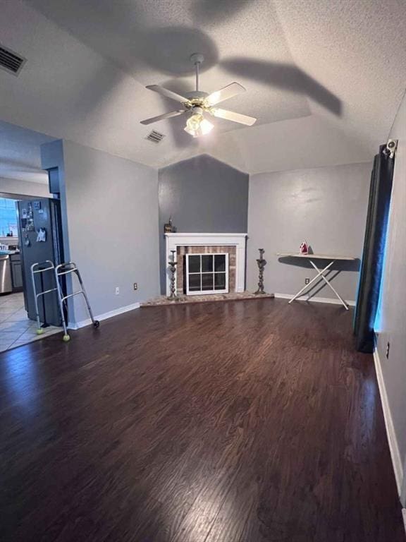 unfurnished living room featuring a textured ceiling, vaulted ceiling, ceiling fan, and dark wood-type flooring