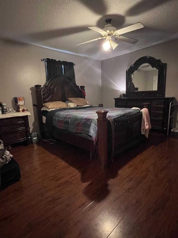 bedroom featuring a textured ceiling, ceiling fan, and dark wood-type flooring