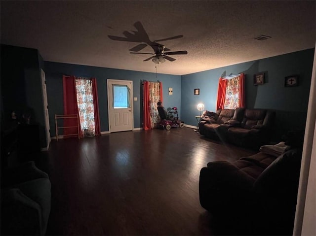 living room featuring wood-type flooring, a textured ceiling, and ceiling fan