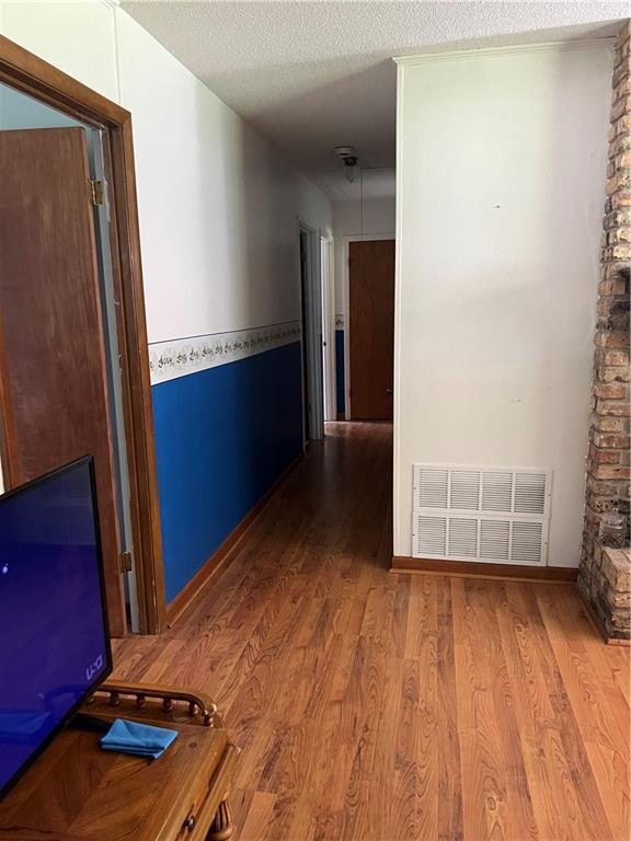 2618 Diberville Dr N, Mobile, AL 36695 - corridor with wood finished floors, a textured ceiling, and baseboards