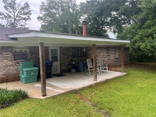 2618 Diberville Dr N, Mobile, AL 36695 - rear view of house with brick siding, a lawn, and a patio