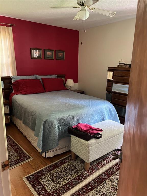 2618 Diberville Dr N, Mobile, AL 36695 - bedroom featuring wood finished floors, a ceiling fan, and a textured ceiling