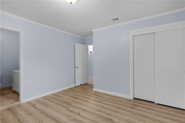 unfurnished bedroom featuring ornamental molding, light hardwood / wood-style floors, and a closet