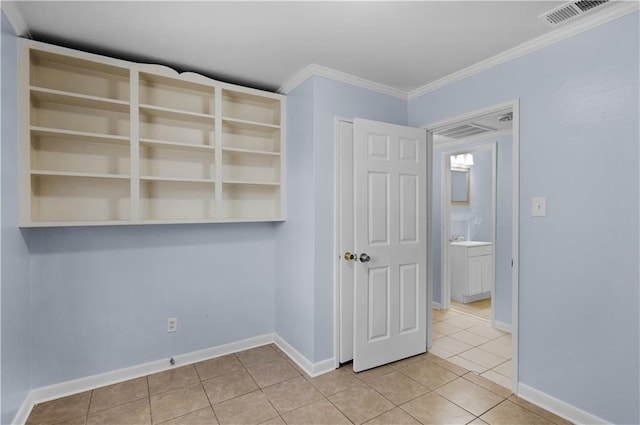 empty room with light tile patterned floors and crown molding