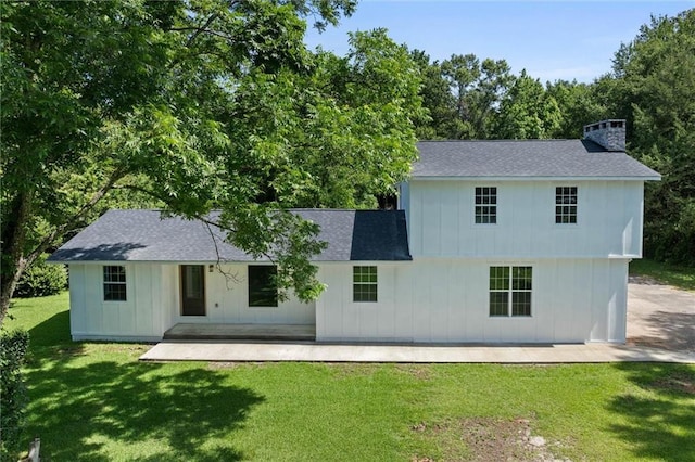 8520 Lebaron Ave W, Citronelle, AL 36522 - rear view of property featuring roof with shingles, a yard, a chimney, and board and batten siding