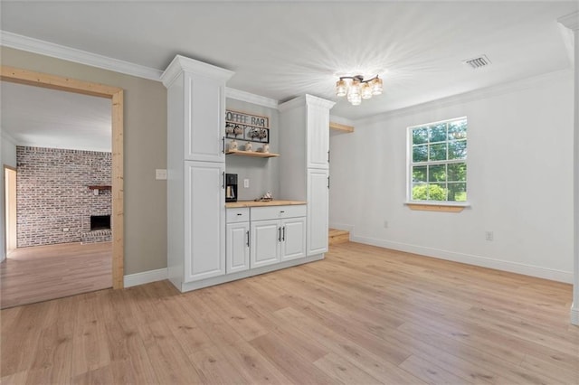8520 Lebaron Ave W, Citronelle, AL 36522 - interior space featuring light wood-style flooring, crown molding, brick wall, a chandelier, and a fireplace