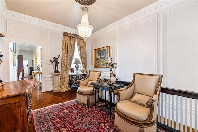 sitting room featuring a notable chandelier, a decorative wall, and crown molding