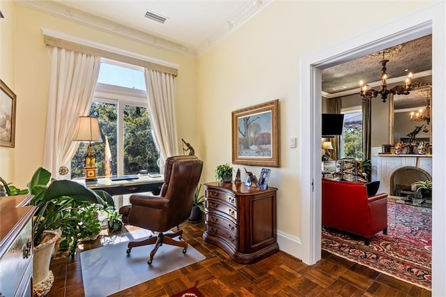 office featuring visible vents, crown molding, baseboards, a chandelier, and a fireplace