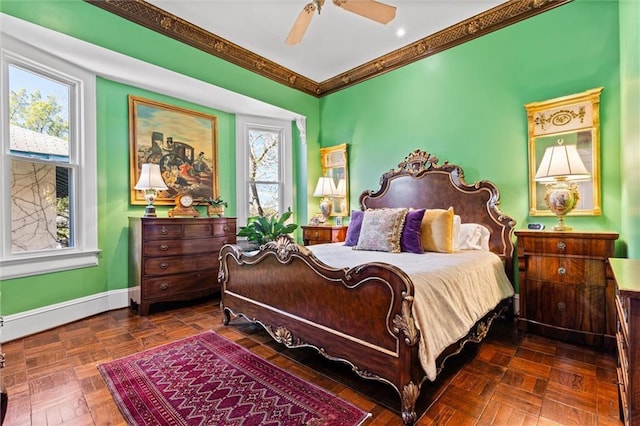 bedroom featuring a ceiling fan, crown molding, and baseboards