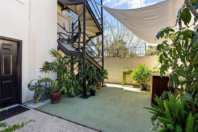 view of patio with stairs and fence