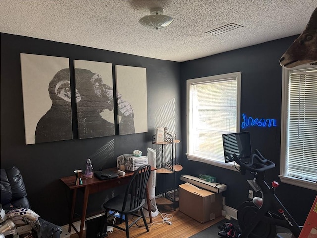 home office with a textured ceiling and wood-type flooring