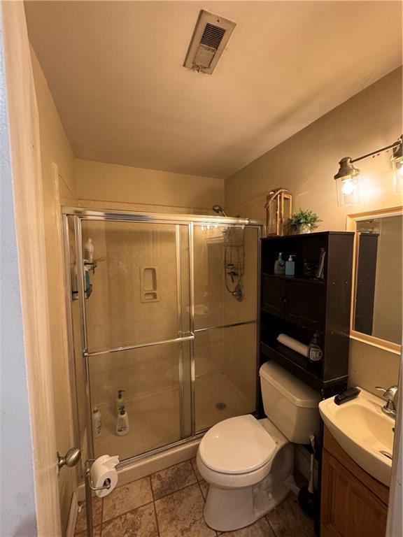 bathroom with vanity, toilet, and walk in shower