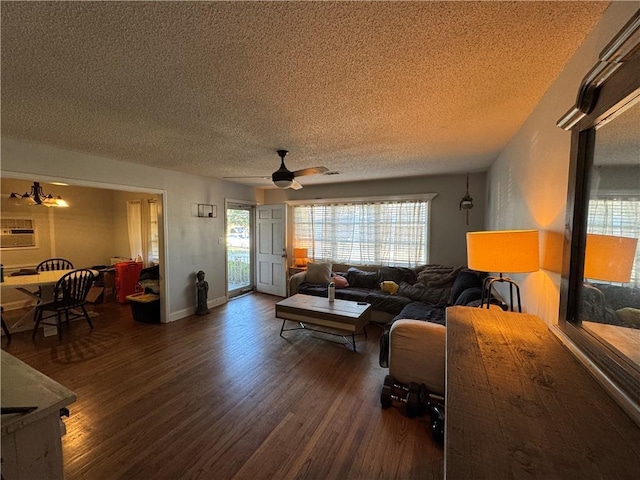 living room featuring ceiling fan, a textured ceiling, dark hardwood / wood-style flooring, and a wall mounted air conditioner