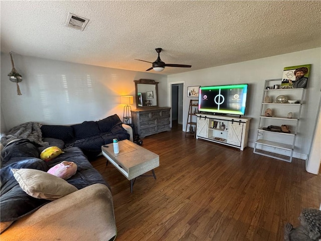 living room featuring a textured ceiling, ceiling fan, and dark hardwood / wood-style flooring