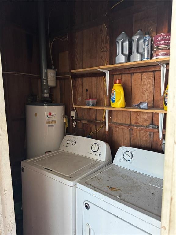 clothes washing area featuring water heater and washer and dryer