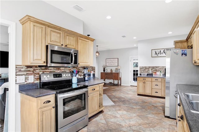 kitchen featuring appliances with stainless steel finishes, light brown cabinetry, sink, and decorative backsplash