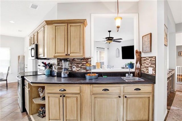 kitchen featuring sink, light tile patterned floors, stainless steel appliances, and backsplash