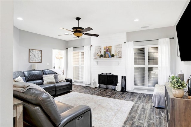 living room featuring dark hardwood / wood-style floors, ceiling fan, and a fireplace