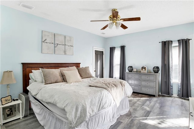 bedroom with dark hardwood / wood-style flooring and ceiling fan