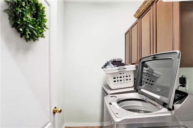 laundry room with cabinets and washing machine and clothes dryer