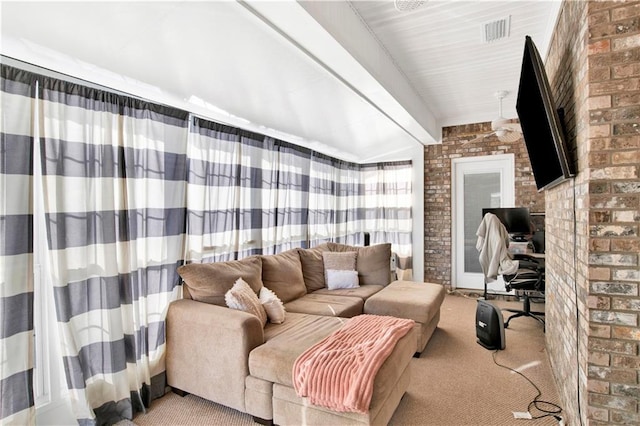 carpeted living room with lofted ceiling with beams and brick wall