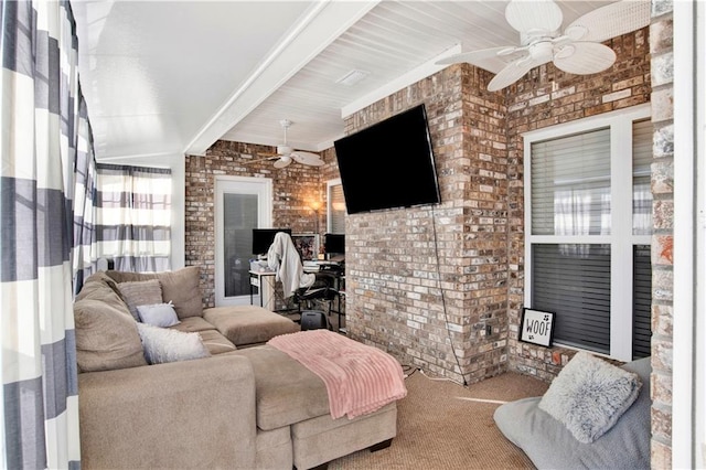 living room featuring beam ceiling, brick wall, carpet, and ceiling fan