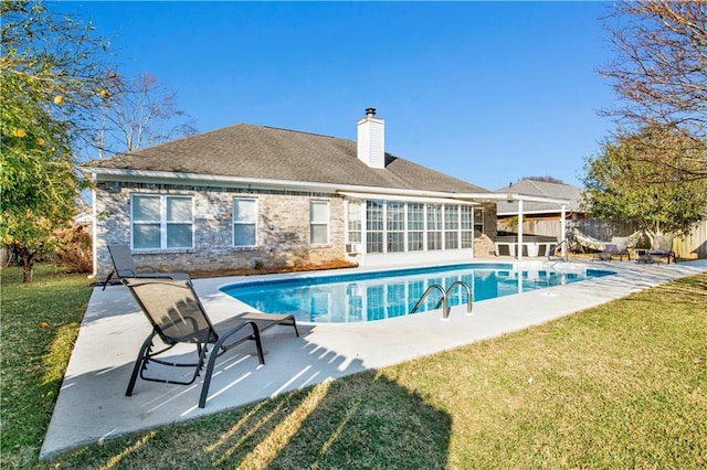 view of swimming pool featuring a patio area and a lawn