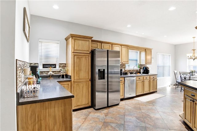 kitchen with sink, hanging light fixtures, a chandelier, and appliances with stainless steel finishes